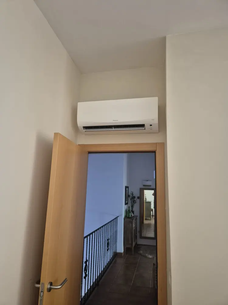 Unidad interior de aire acondicionado instalada sobre una puerta