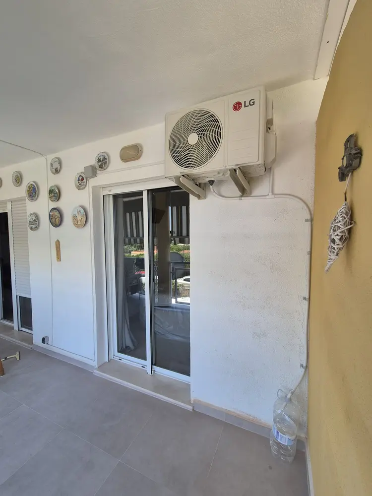 Unidad exterior de aire acondicionado instalada en una terraza